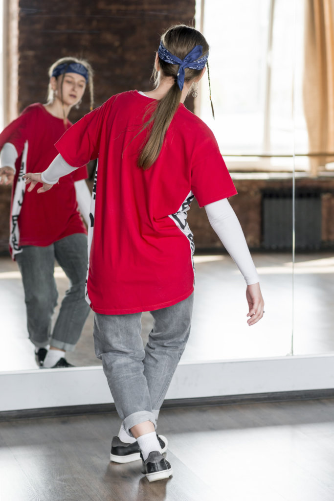 A young woman dancing in front of mirror