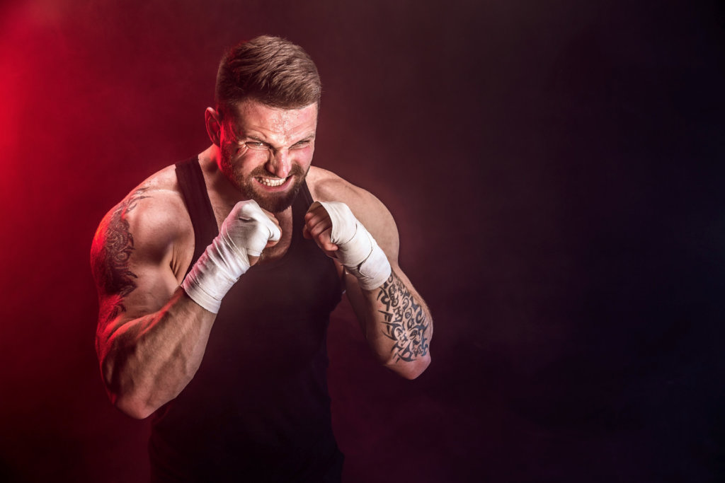 Sportsman muay thai boxer fighting on black background